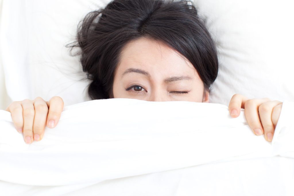 Was bringt den Körper morgens in Schwung? 1 Frau liegt verschlafen im Bett Kreislauf