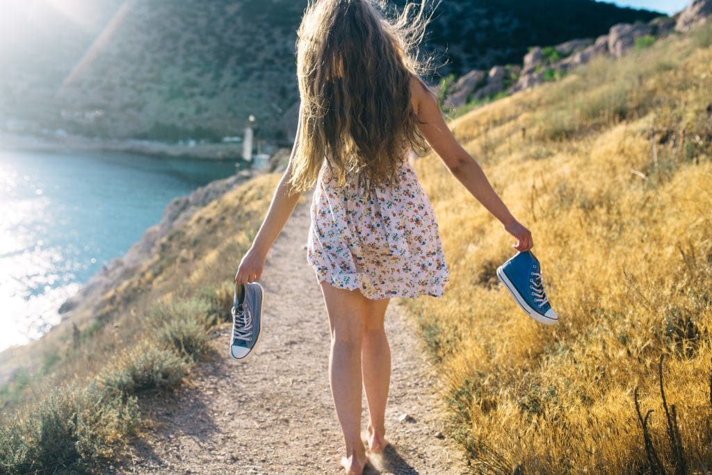Back to the roots - Wie Barfußlaufen gegen Rückenschmerzen hilft 8 Mädchen mit Schuhen in der Hand in der Natur