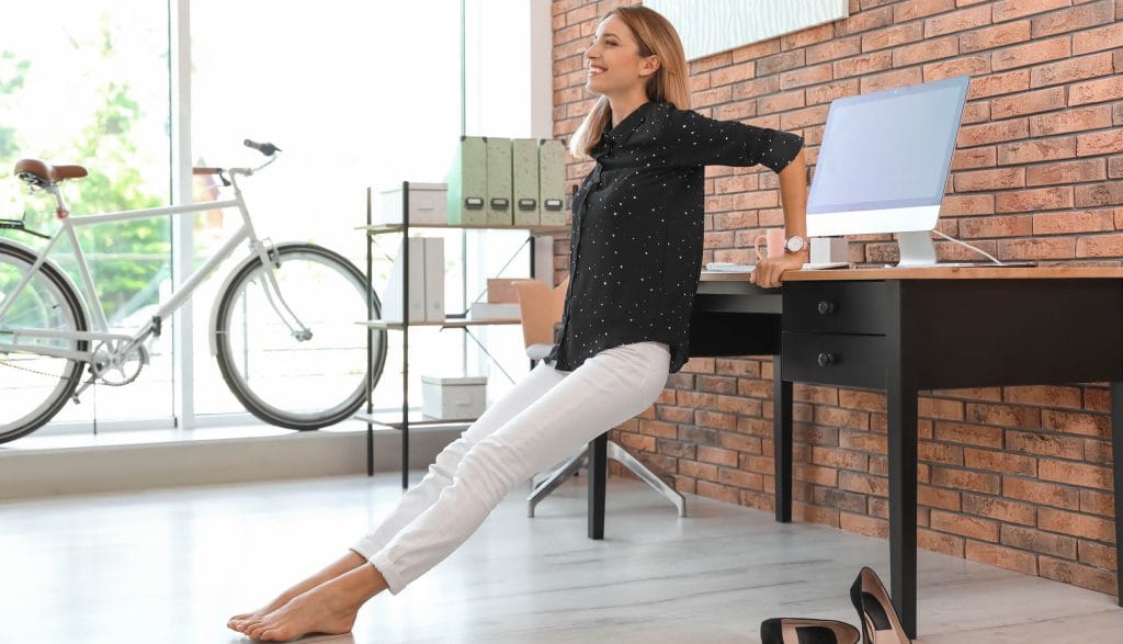 Frau übt Bewegung am Arbeitsplatz aus